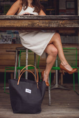Market tote by Newton Supply. Coal-colored hand-waxed cotton bag with veg-tan leather handles attached by brass rivets.