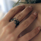 A woman wearing two Double Dot open-ended oxidized silver and gold dot rings stacked on either side of a closed single dot ring.