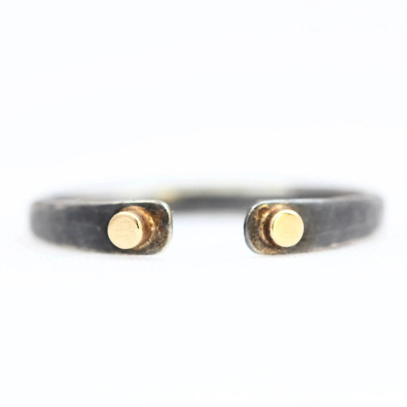 The open-ended Double Dot ring with a 14k gold dot on both ends of an oxidized silver band.
