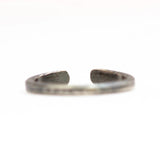 Back view of the hammered oxidized sterling silver band. Point of focus is the opening with flattened ends.
