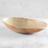 Side view of Colleen Hennessey's oval ceramic bowl in rust and wheat.