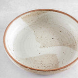 Top view of Colleen Hennessey's matte speckled ceramic serving bowl with unglazed rim.