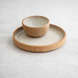 Dune ceramic spice bowl on an olive dish by Earthen against a light concrete background.