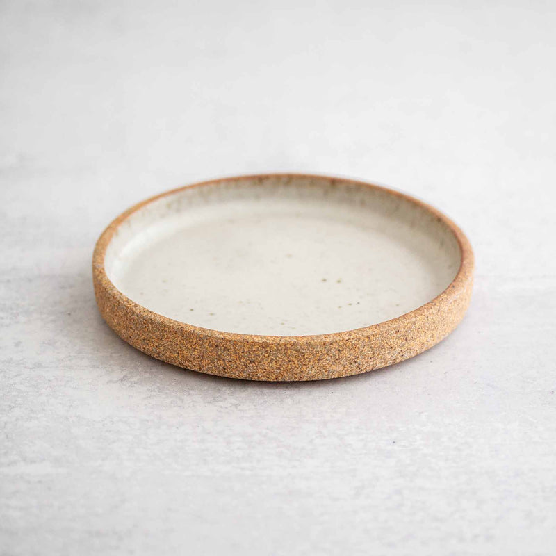 Dune ceramic olive dish by Earthen against a light concrete background.