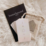 Homebound Tarot's self-care tarot deck with guidebook and cotton muslin pouch on a fur.
