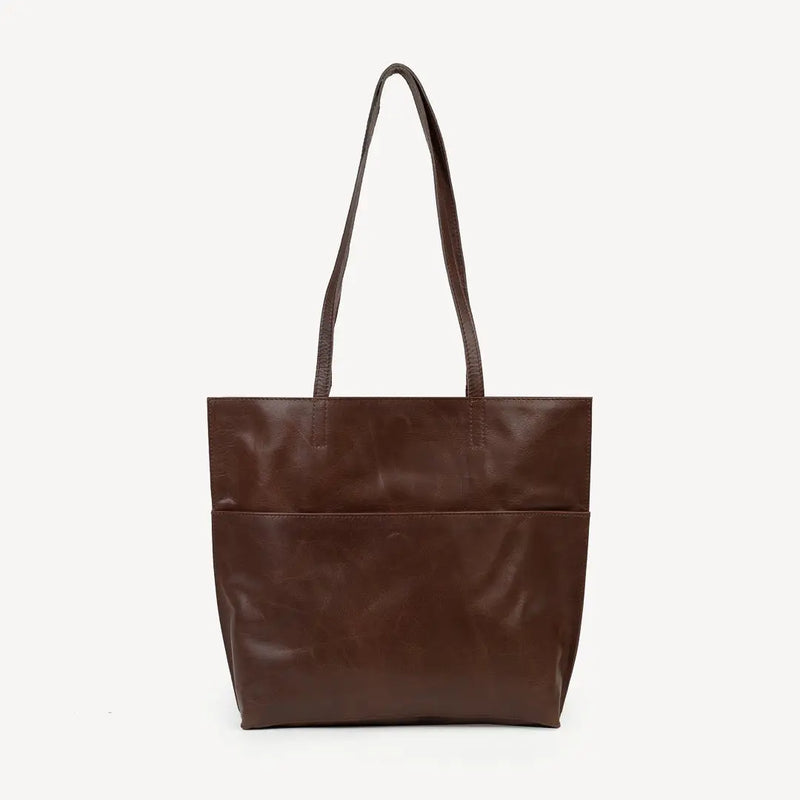 JOYN Bags' Everyday Tote in Heritage Brown (very dark, rich coffee color). Sustainably made with full-grain remnant leather. Shown from back. The large exterior pocked secures with a hidden magnet.