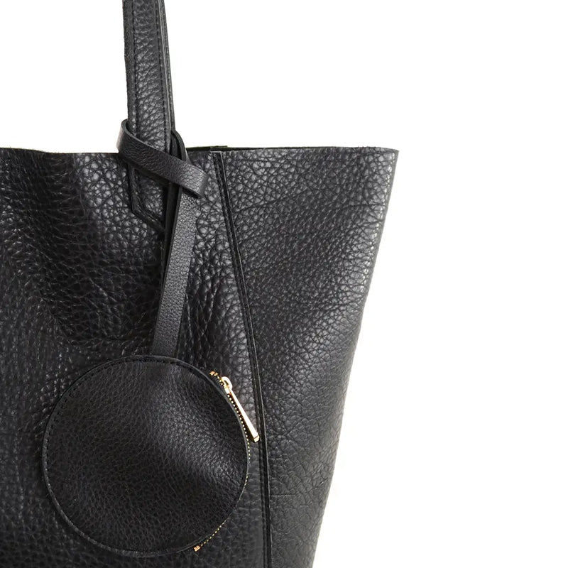 The buttery-soft black pebble leather June tote by Shana Luther. This is a close-up shot of the attached coin fob that's perfect for holding keys or your metro pass.